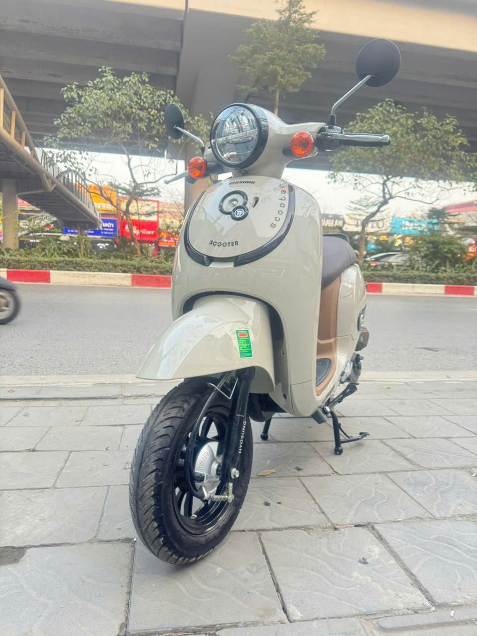 Với nh&oacute;m kh&aacute;ch h&agrave;ng như học sinh, sinh vi&ecirc;n, người đi l&agrave;m gần hay c&aacute;c gia đ&igrave;nh sống trong khu d&acirc;n cư, sự ổn định v&agrave; tiện dụng đặc biệt đi xe kh&ocirc;ng cần bằng l&aacute;i với người chưa đủ 18 tuổi hoặc nhiều tuổi kh&ocirc;ng học được bằng l&aacute;i thường quan trọng hơn mọi yếu tố kh&aacute;c. Được ph&aacute;t triển theo đ&uacute;ng tinh thần đ&oacute;, Xe Ga 50cc Giorno HSV2 Hyosung hướng đến những người d&ugrave;ng cần một chiếc xe đi thật, d&ugrave;ng thật v&agrave; gắn b&oacute; l&acirc;u d&agrave;i, thay v&igrave; chỉ đẹp tr&ecirc;n showroom. Giorno HSV2 Hyosung 50cc nhỏ gọn, dễ l&aacute;i Xe ga 50cc Giorno HSV2 được thiết kế theo hướng nhỏ gọn nhưng vẫn tạo cảm gi&aacute;c chắc chắn khi nh&igrave;n trực diện. Với chiều d&agrave;i khoảng 1.710 mm, rộng 710 mm v&agrave; cao 1.050 mm, xe đủ linh hoạt để len lỏi trong phố đ&ocirc;ng, xoay trở dễ d&agrave;ng trong b&atilde;i gửi xe hay những con hẻm chật hẹp. Trọng lượng khoảng 79 kg gi&uacute;p người d&ugrave;ng kể cả nữ giới hoặc người mới l&aacute;i c&oacute; thể dắt, dựng v&agrave; quay đầu xe nhẹ nh&agrave;ng hơn. Chiều cao y&ecirc;n 750 mm kh&aacute; ph&ugrave; hợp với thể trạng người Việt, gi&uacute;p người l&aacute;i chống ch&acirc;n vững v&agrave;ng khi dừng đ&egrave;n đỏ hay quay đầu trong kh&ocirc;ng gian nhỏ. Tư thế ngồi tự nhi&ecirc;n, tay l&aacute;i vừa tầm, s&agrave;n để ch&acirc;n phẳng v&agrave; rộng gi&uacute;p việc di chuyển hằng ng&agrave;y trở n&ecirc;n thoải m&aacute;i thay v&igrave; mệt mỏi. Thay v&igrave; chạy theo phong c&aacute;ch c&aacute; t&iacute;nh mạnh hay qu&aacute; &ldquo;tương lai&rdquo;, Xe Ga 50cc Giorno HSV2 Hyosung đi theo lối thiết kế h&agrave;i h&ograve;a, dễ chấp nhận với nhiều độ tuổi. Cụm đ&egrave;n pha tr&ograve;n mang n&eacute;t cổ điển nhẹ nh&agrave;ng, kết hợp c&aacute;c đường bo th&acirc;n xe mềm mại tạo cảm gi&aacute;c th&acirc;n thiện hơn l&agrave; sắc cạnh. D&agrave;n &aacute;o nhựa ho&agrave;n thiện tốt, bề mặt sơn đều m&agrave;u gi&uacute;p xe giữ được vẻ ngo&agrave;i tươi mới sau thời gian d&agrave;i sử dụng ngo&agrave;i trời. Bảng m&agrave;u đa dạng từ c&aacute;c t&ocirc;ng pastel đến gam trầm, ph&ugrave; hợp cả học sinh, sinh vi&ecirc;n lẫn người trưởng th&agrave;nh &ndash; đ&uacute;ng chất một chiếc xe &ldquo;d&ugrave;ng chung trong gia đ&igrave;nh&rdquo; m&agrave; kh&ocirc;ng bị lệch gu. Tiết kiệm xăng cũng l&agrave; điều người d&ugrave;ng quan t&acirc;m Giorno HSV2 Hyosung 50cc sử dụng động cơ xăng 4 th&igrave; dung t&iacute;ch 49.5cc, l&agrave;m m&aacute;t bằng kh&ocirc;ng kh&iacute;, loại động cơ quen thuộc, bền bỉ v&agrave; dễ bảo dưỡng. Xe đạt tốc độ tối đa khoảng 50 km/h, đủ cho nhu cầu đi học, đi l&agrave;m gần hoặc di chuyển trong khu d&acirc;n cư m&agrave; kh&ocirc;ng g&acirc;y &aacute;p lực kiểm so&aacute;t cho người l&aacute;i. Mức ti&ecirc;u hao nhi&ecirc;n liệu chỉ khoảng 1.68 l&iacute;t/100 km, kết hợp b&igrave;nh xăng 4.5 l&iacute;t gi&uacute;p xe c&oacute; thể đi hơn 250 km cho mỗi lần đổ đầy &ndash; một lợi thế r&otilde; rệt với người d&ugrave;ng đ&ocirc; thị muốn giảm chi ph&iacute; h&agrave;ng th&aacute;ng. Hệ thống giảm x&oacute;c trước dạng ống lồng v&agrave; giảm x&oacute;c sau thủy lực gi&uacute;p xe vận h&agrave;nh &ecirc;m hơn khi qua gờ giảm tốc hay mặt đường gồ ghề. Phanh đĩa trước v&agrave; tang trống sau mang lại lực phanh dễ kiểm so&aacute;t, ph&ugrave; hợp với người mới l&aacute;i, trong khi lốp kh&ocirc;ng săm Kenda tăng độ b&aacute;m đường v&agrave; hạn chế rủi ro x&igrave; lốp đột ngột. Cốp xe dưới y&ecirc;n đủ để chứa mũ bảo hiểm nửa đầu, &aacute;o mưa v&agrave; một số vật dụng c&aacute; nh&acirc;n &ndash; vừa vặn với nhu cầu sử dụng hằng ng&agrave;y. Bảng đồng hồ cơ đơn giản, dễ quan s&aacute;t, th&acirc;n thiện với cả học sinh lẫn người lớn tuổi kh&ocirc;ng th&iacute;ch m&agrave;n h&igrave;nh điện tử phức tạp. Cấu tr&uacute;c xe kh&ocirc;ng qu&aacute; cầu kỳ gi&uacute;p việc bảo dưỡng nhanh gọn, linh kiện phổ biến v&agrave; dễ thay thế. Khung xe được sơn tĩnh điện, tăng khả năng chống gỉ trong điều kiện thời tiết n&oacute;ng ẩm của Việt Nam, gi&uacute;p xe bền bỉ hơn theo thời gian. Đ&aacute;nh gi&aacute; từ người đ&atilde; sử dụng xe Giorno HSV2 Hyosung 50cc Điểm mạnh của Giorno HSV2 kh&ocirc;ng chỉ nằm ở th&ocirc;ng số m&agrave; c&ograve;n ở c&aacute;ch xe thể hiện trong thực tế sử dụng. Khi di chuyển trong giờ cao điểm, xe cho cảm gi&aacute;c điều khiển nhẹ nh&agrave;ng, kh&ocirc;ng bị &igrave; m&aacute;y hay kh&oacute; tăng tốc. Tay l&aacute;i phản hồi ổn định, gi&uacute;p người l&aacute;i dễ d&agrave;ng giữ thăng bằng khi đi chậm hoặc l&aacute;ch qua c&aacute;c phương tiện kh&aacute;c. Với học sinh, xe đủ nhẹ để dắt ra v&agrave;o trường học, dễ xoay trở trong b&atilde;i giữ xe đ&ocirc;ng đ&uacute;c. Với sinh vi&ecirc;n hay người đi l&agrave;m gần, Giorno HSV2 l&agrave; phương tiện tiết kiệm v&agrave; &iacute;t g&acirc;y &aacute;p lực về chi ph&iacute; bảo dưỡng. Với c&aacute;c gia đ&igrave;nh, đ&acirc;y l&agrave; lựa chọn l&yacute; tưởng l&agrave;m xe phụ để đi chợ, đưa đ&oacute;n con c&aacute;i hoặc di chuyển trong khu d&acirc;n cư. Đặc biệt, khả năng vận h&agrave;nh &ecirc;m &aacute;i gi&uacute;p xe ph&ugrave; hợp với người lớn tuổi hoặc những người mới l&agrave;m quen với xe ga. Kh&ocirc;ng c&oacute; cảm gi&aacute;c giật cục hay qu&aacute; nhạy khi tăng ga, gi&uacute;p người d&ugrave;ng tự tin hơn trong qu&aacute; tr&igrave;nh điều khiển. Khi chọn xe, nhiều người thường chỉ nh&igrave;n v&agrave;o gi&aacute; mua ban đầu m&agrave; qu&ecirc;n mất chi ph&iacute; vận h&agrave;nh v&agrave; bảo dưỡng trong d&agrave;i hạn. Ở điểm n&agrave;y, Giorno HSV2 Hyosung Korea thể hiện r&otilde; lợi thế. Với cấu tr&uacute;c động cơ đơn giản, việc bảo dưỡng định kỳ chủ yếu xoay quanh thay nhớt, kiểm tra phanh, lốp v&agrave; hệ thống điện &ndash; những hạng mục kh&ocirc;ng tốn nhiều chi ph&iacute;. Linh kiện phổ biến tr&ecirc;n thị trường gi&uacute;p việc sửa chữa dễ d&agrave;ng v&agrave; nhanh ch&oacute;ng nếu cần. B&ecirc;n cạnh đ&oacute;, mức ti&ecirc;u hao nhi&ecirc;n liệu thấp gi&uacute;p người d&ugrave;ng tiết kiệm đ&aacute;ng kể tiền xăng theo thời gian. Nếu sử dụng xe h&agrave;ng ng&agrave;y để đi học hoặc đi l&agrave;m gần, khoản tiết kiệm n&agrave;y sẽ rất r&otilde; r&agrave;ng sau v&agrave;i th&aacute;ng sử dụng. Khung xe được xử l&yacute; chống gỉ tốt, d&agrave;n &aacute;o bền m&agrave;u v&agrave; &iacute;t xuống cấp theo thời gian, gi&uacute;p xe giữ gi&aacute; tốt hơn khi muốn b&aacute;n lại hoặc đổi xe sau n&agrave;y. Tất cả những yếu tố n&agrave;y khiến Giorno HSV2 kh&ocirc;ng chỉ l&agrave; lựa chọn hợp l&yacute; ở thời điểm mua, m&agrave; c&ograve;n l&agrave; quyết định kinh tế th&ocirc;ng minh về l&acirc;u d&agrave;i. Xe Ga Giorno HSV2 Hyosung 50cc kh&ocirc;ng phải mẫu xe để g&acirc;y ấn tượng mạnh ngay từ c&aacute;i nh&igrave;n đầu ti&ecirc;n, nhưng lại l&agrave; chiếc xe khiến người d&ugrave;ng y&ecirc;n t&acirc;m mỗi ng&agrave;y. Nhỏ gọn, dễ l&aacute;i, tiết kiệm nhi&ecirc;n liệu, &iacute;t hỏng vặt v&agrave; vận h&agrave;nh ổn định tất cả tạo n&ecirc;n một phương tiện thực sự ph&ugrave; hợp với nhịp sống đ&ocirc; thị hiện đại. Nếu bạn đang t&igrave;m kiếm một chiếc xe kh&ocirc;ng cần bằng l&aacute;i, chi ph&iacute; thấp, dễ sử dụng v&agrave; đủ bền để đồng h&agrave;nh l&acirc;u d&agrave;i, Giorno HSV2 l&agrave; lựa chọn rất đ&aacute;ng c&acirc;n nhắc. Đ&acirc;y kh&ocirc;ng chỉ l&agrave; một chiếc xe ga 50cc, m&agrave; l&agrave; giải ph&aacute;p di chuyển thực tế cho những ai coi trọng sự tiện lợi, kinh tế v&agrave; ổn định hơn l&agrave; h&agrave;o nho&aacute;ng b&ecirc;n ngo&agrave;i.